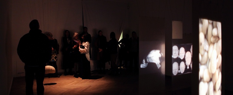 Personer i mørkt udstillingsrum