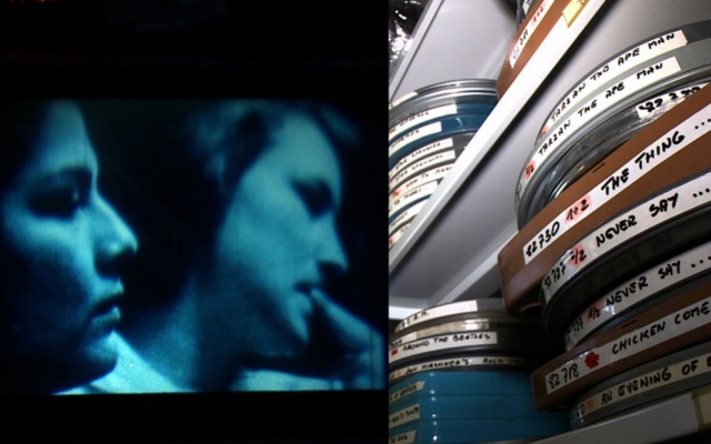 En skærm der viser to ansigter i profil og stablede filmruller