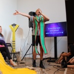 Person iført kostume synger kareoke mens yderligere to personer iklædt kostume og tilskuere ser på